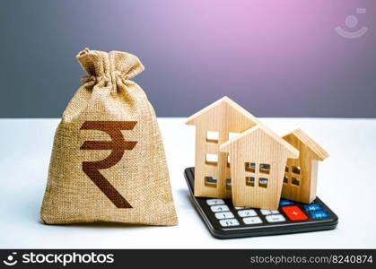 Houses on a calculator and indian rupee money bag. Buying and selling. Real estate valuation. Building maintenance. Mortgage loan. Utilities and services expenses. Taxes, budget. Realty business.