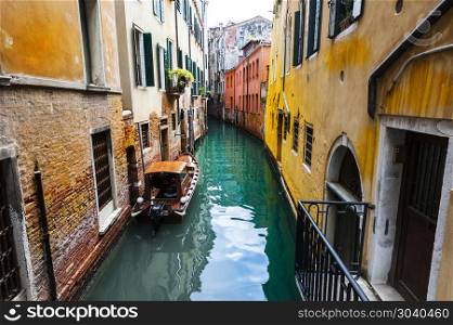 Houses peeling off from dampness. Venice is situated across a group of islands that are separated by canals and linked by bridges. Gondola is a traditional, flat-bottomed Venetian rowing boat. Damage from dampness in Venice