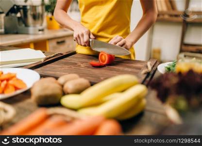 Housewife cooking on the kitchen, healthy eco food. Vegetarian diet, fresh vegetables and fruits on wooden table