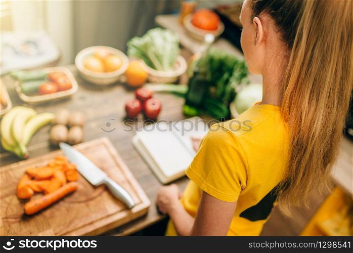 Housewife cooking on the kitchen, healthy organic food. Vegetarian diet, fresh vegetables and fruits on wooden table