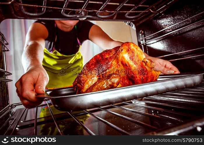 Housewife prepares roast chicken in the oven, view from the inside of the oven. Cooking in the oven.