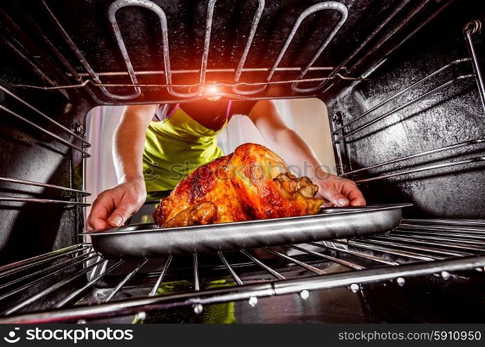 Housewife prepares roast chicken in the oven, view from the inside of the oven. Cooking in the oven. Thanksgiving Day.