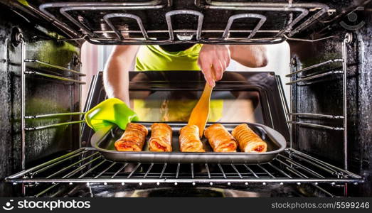 Housewife preparing cakes in the oven at home, view from the inside of the oven. Cooking in the oven.