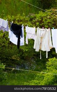 Housework. Clean wet laundry clothes hanging to dry on the line clothesline outdoor. Rural scene.