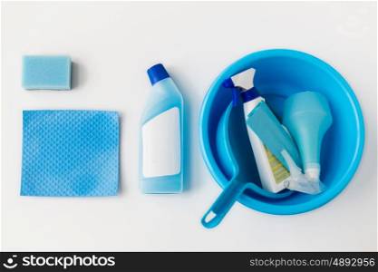 housework, housekeeping and household concept - basin with cleaning stuff on white background