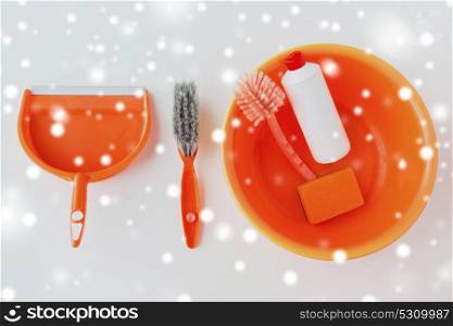 housework, housekeeping and household concept - basin with cleaning stuff on white background over snow. basin with cleaning stuff on white background