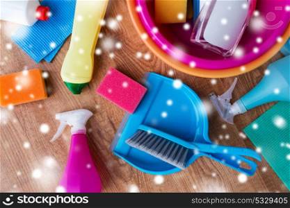 housework, housekeeping and household concept - basin with cleaning stuff on wooden floor over snow. basin with cleaning stuff on wooden floor