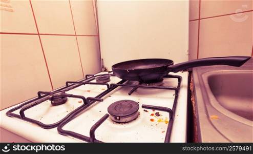 Housework, hygiene and cleaning concept. Dirt at home. Dirty filthy gas stove with used kitchen cooking stuff, frying pan