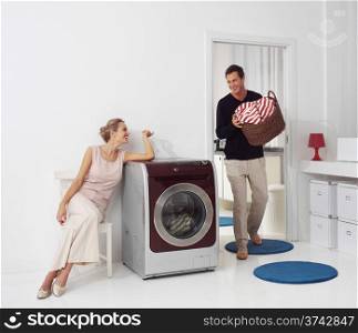 Housework, young woman and man doing laundry