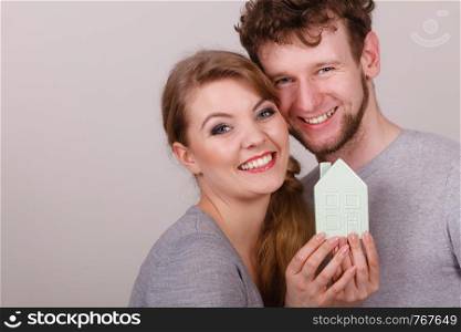 Housing property ownership marriage family future mortgage concept. Young enamoured pair showing house symbol. Man with lady presenting home model.. Young enamoured pair showing house symbol.