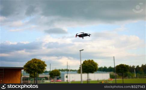 Hovering drone flying upward on a cloudy sky backdrop. copter flying. Hovering drone flying upward on a cloudy sky backdrop. copter flying .