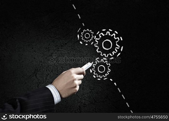 How it works. Close up of hand drawing gears mechanism with chalk
