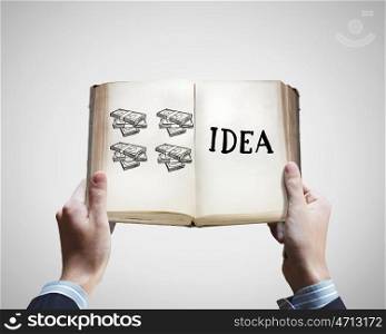 How to earn money. Opened book in male hands with financial ideas on pages