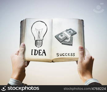 How to earn money. Opened book in male hands with financial ideas on pages