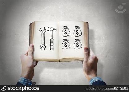 How to earn money. Opened book in male hands with financial ideas on pages