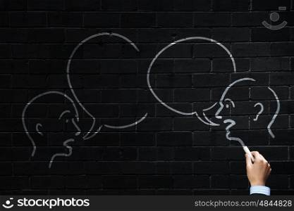 How to keep dialogue going. Close up of hand drawing dialogue between two on blackboard