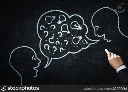 How to keep dialogue going. Close up of hand drawing dialogue between two on blackboard