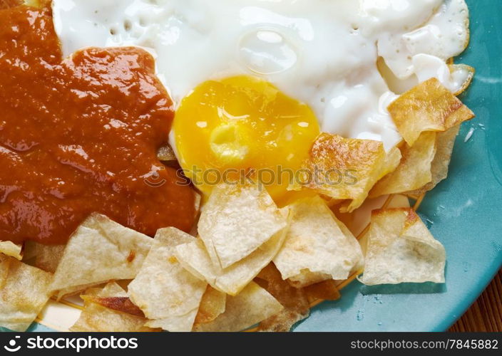 Huevos con chilaquiles - Mexican traditional breakfast eggs. Eggs with tortilla chips topped with red sauce.