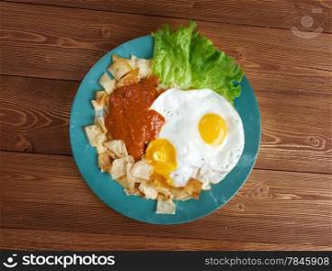 Huevos con chilaquiles - Mexican traditional breakfast eggs. Eggs with tortilla chips topped with red sauce.