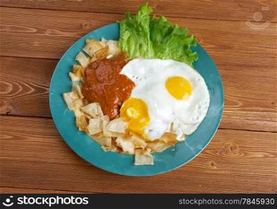 Huevos con chilaquiles - Mexican traditional breakfast eggs. Eggs with tortilla chips topped with red sauce.
