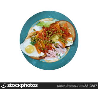 Huevos Motulenos - breakfast food in the town of Motul (Yucatan) dish is made with eggs on tortillas , ham, peas, plantains, and salsa picante