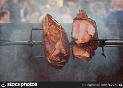 huge chunks of pork roasting on a spit