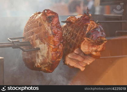 huge chunks of pork roasting on a spit