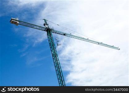 Huge construction crane with cloudy sky background