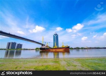 Huge Container Ship entering port of Bangkok, passing under the Bridge