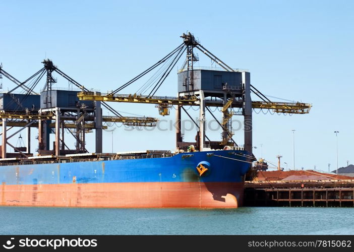 Huge cranes unloading ore from a bulk carrier