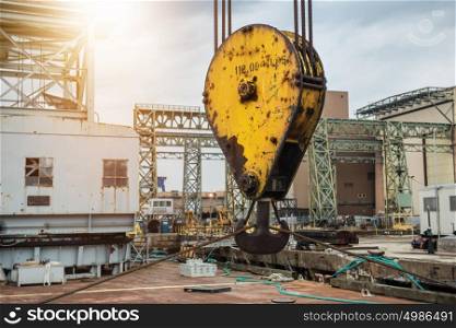 Huge industrial crane hook in the port for container cargo lifting.