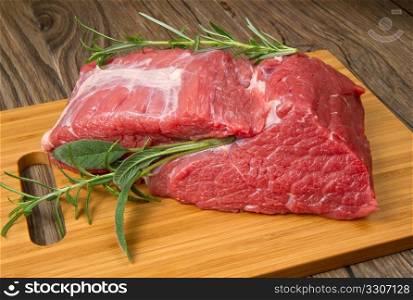 huge red meat chunk on wooden table