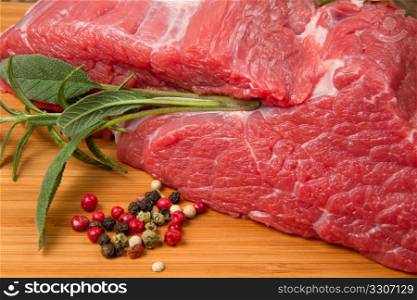 huge red meat chunk on wooden table