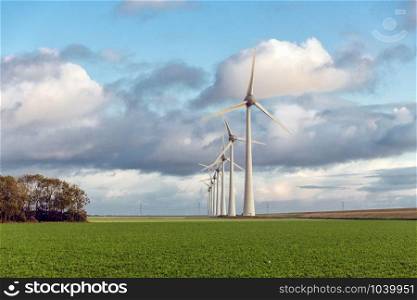 Huge wind turbines in Dutch agricultural landscape with beautiful clouds. Huge wind turbines in Dutch agricultural landscape