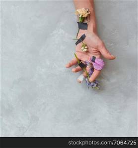 Human being&rsquo;s hand with flowers as decoration or designing for any post card. Grey copy space background may be used for your expressing positive emotions on holiday.. Human being&rsquo;s hand with flowers