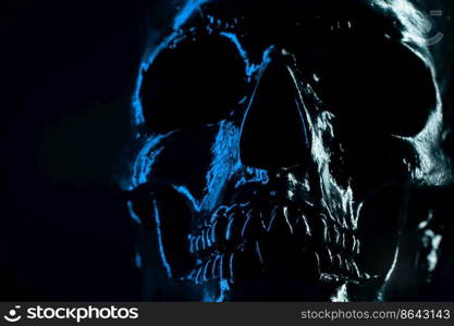 Human blue skull on dark background. Concept of fear, death and horror, Halloween celebration. Spooky and sinister. Human blue skull on dark background. Concept of fear, death and horror, Halloween celebration. Spooky and sinister.