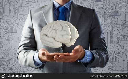 Human brain. Close up of businessman hand holding brain in palm