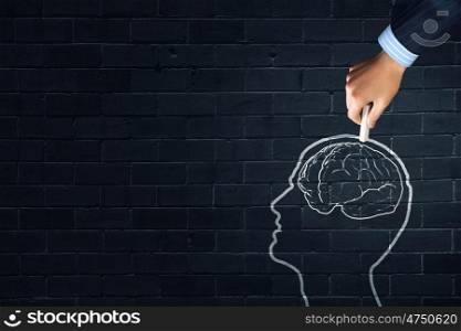 Human brain. Human hand drawing brain on black chalkboard