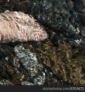 Human foot in water on the beach, Birchy Head, Bonne Bay, Gros Morne National Park, Newfoundland and Labrador, Canada