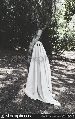 human ghost costume near tree forest