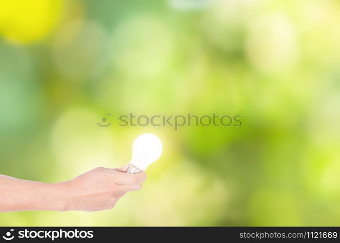 Human hand concept, saving energy from light bulbs, natural bokeh background