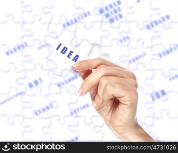 Human hand holding a piece of puzzle with business word
