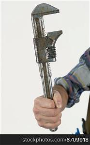 Human hand holding a pipe wrench