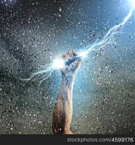 Human hand holding lightning. Close-up of human hand clenching lightning flash