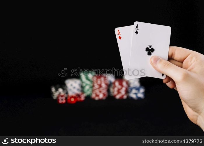 human hand holding two aces playing cards