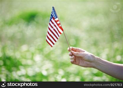 Human hand holding US flag for Independence Day