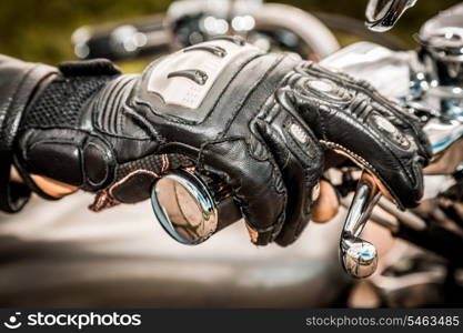 Human hand in a Motorcycle Racing Gloves holds a motorcycle throttle control. Hand protection from falls and accidents.