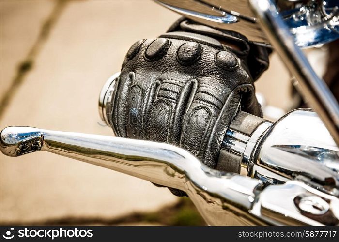 Human hand in a Motorcycle Racing Gloves holds a motorcycle throttle control. Hand protection from falls and accidents.