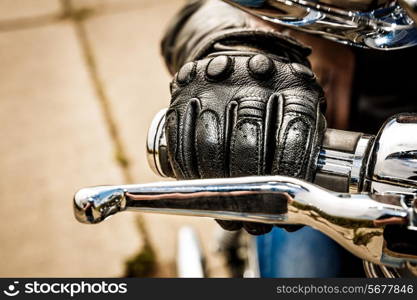 Human hand in a Motorcycle Racing Gloves holds a motorcycle throttle control. Hand protection from falls and accidents.