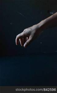 Human hand on a black background, in the dark